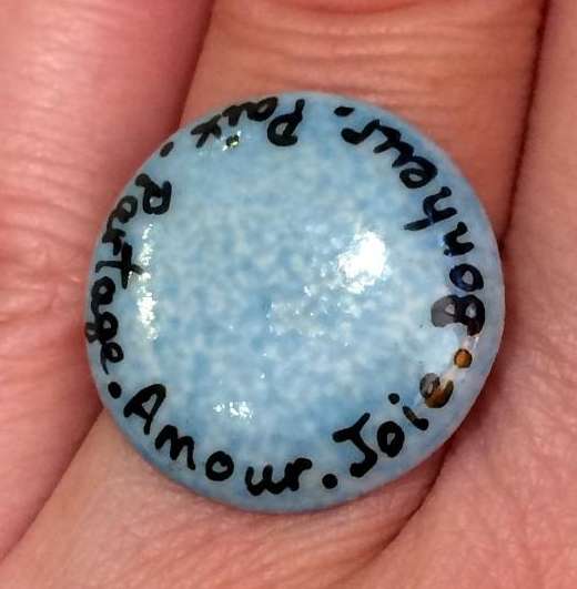 Bague ronde personnalisée par des mots sur un fond bleu turquoise